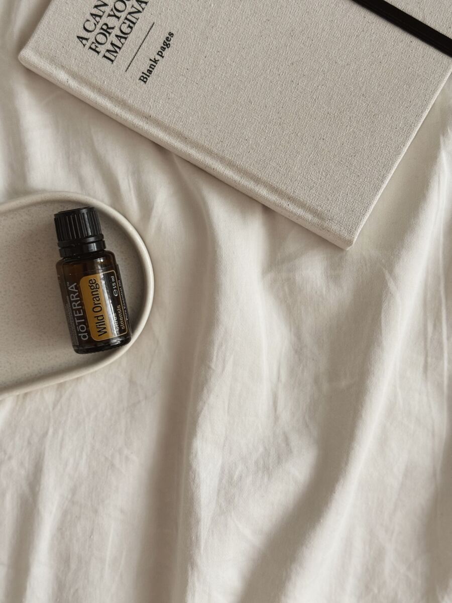 Wild Orange oil on a ceramic tray beside a linen notebook